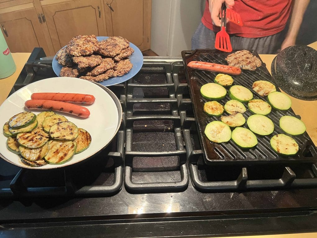 cooking hamburgers, hot dogs, and zucchini