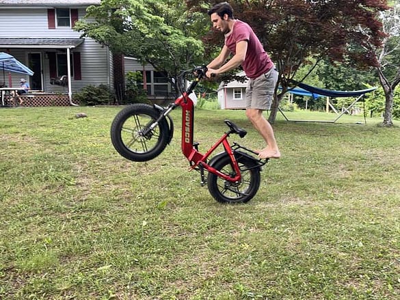 boy riding e-bike on one wheel-risky play