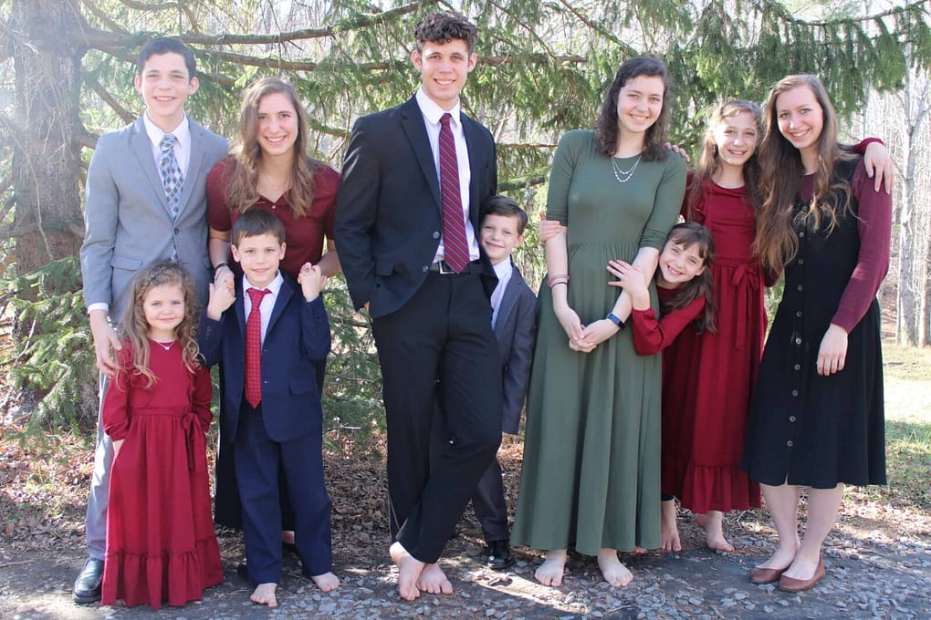 10 children wearing Christmas colors for family picture