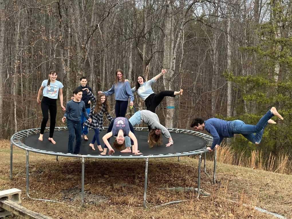 9 kids doing crazy poses on a trampoline