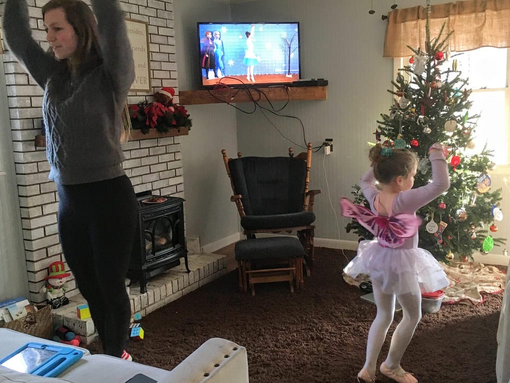 22 year old older sister doing ballet with 5 year old little sister in a ballerina outfit in the living room