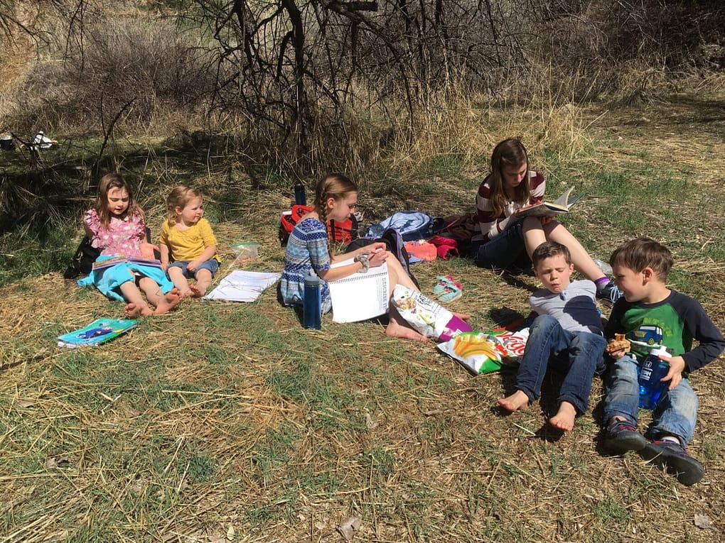 7 children doing schoool outside on a warm late winter day