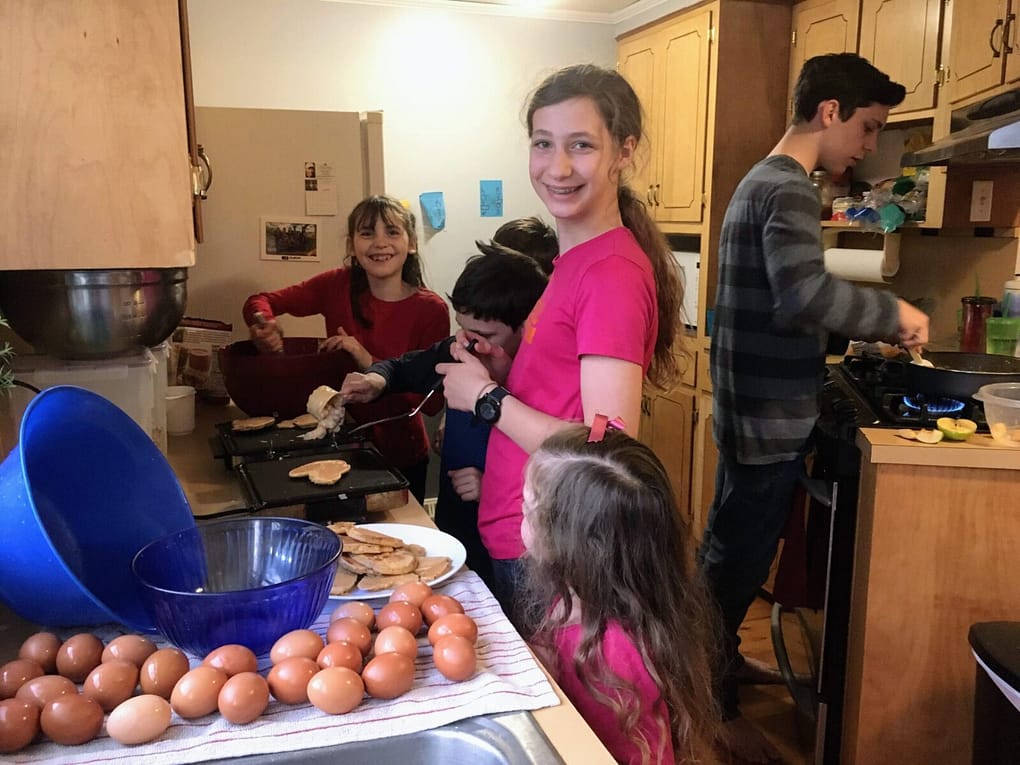 6 children making a valentine dinner of pancakes