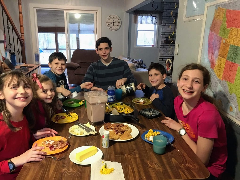 family of 6 children eating a valentine dinner of pancakes