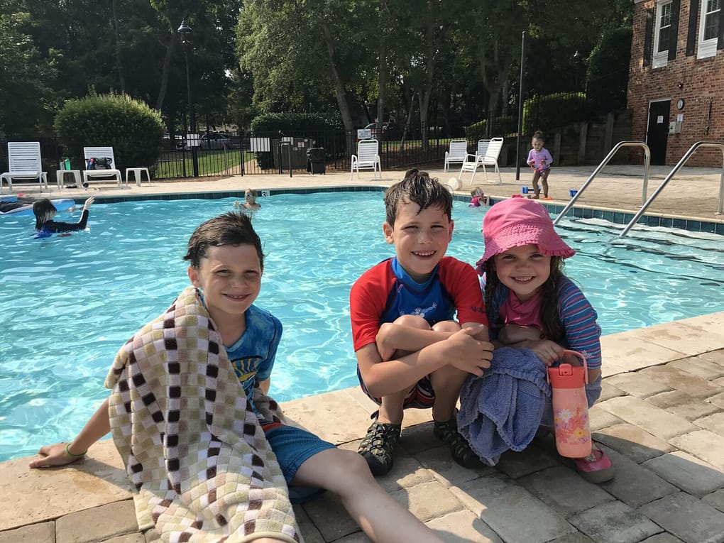 3 kids at an apartment pool