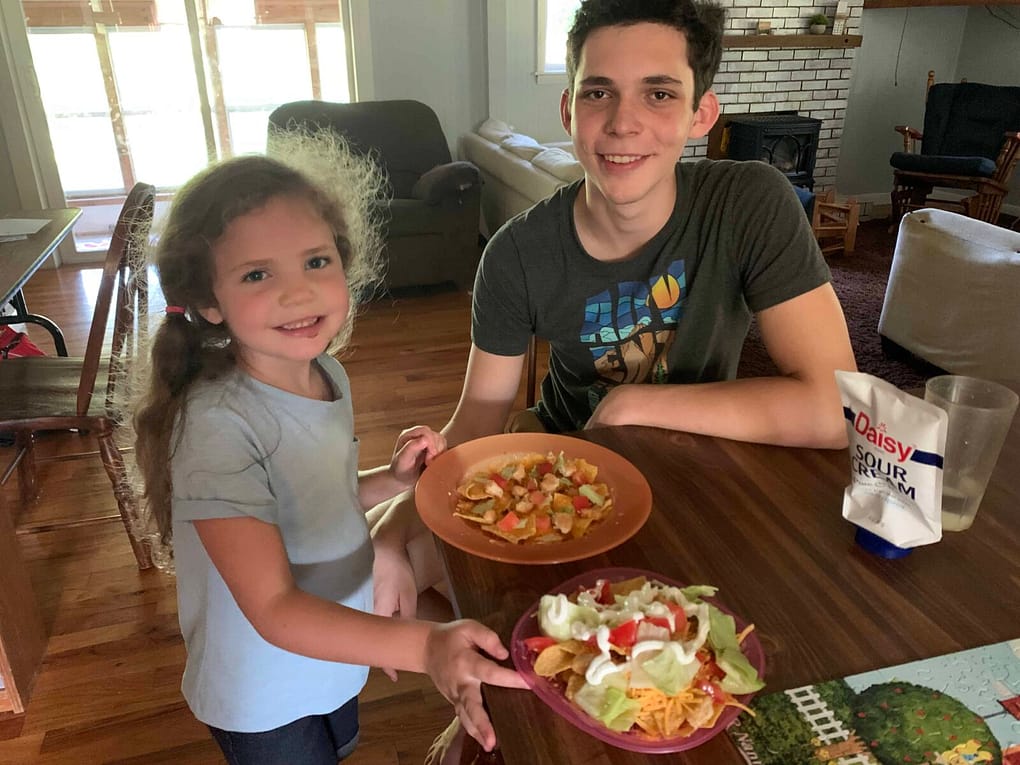 brother and little sister with their plates of nachos