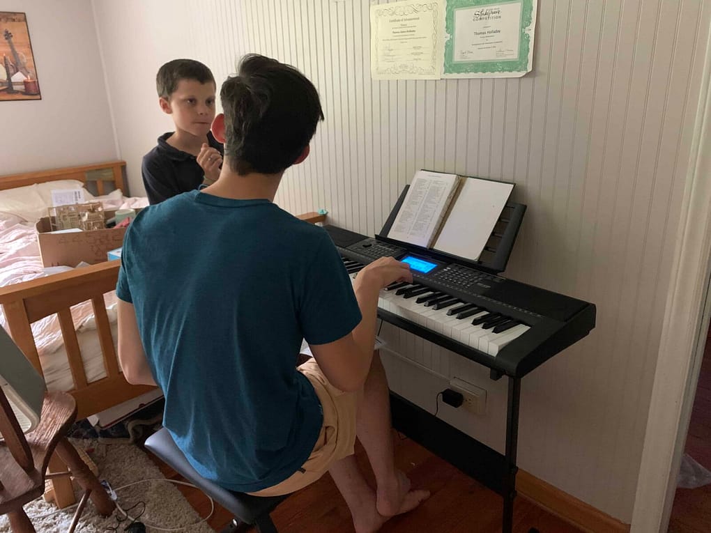 brothers playing a little digital piano