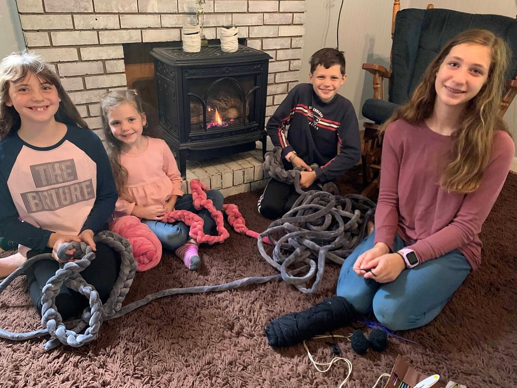 kids finger crocheting by fire
