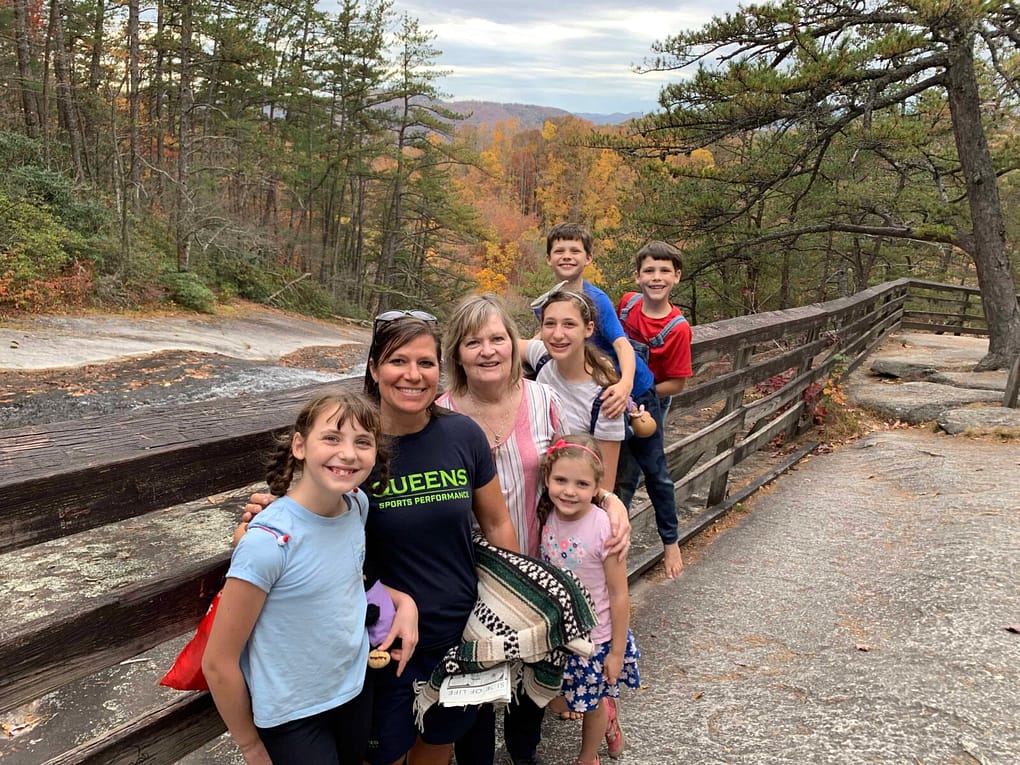 large family posing in front of stone mountain waterfall