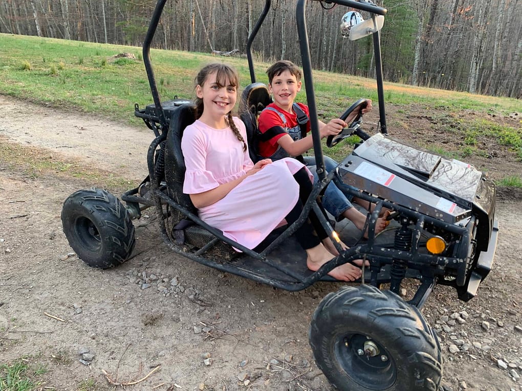 two siblings riding in a gocart