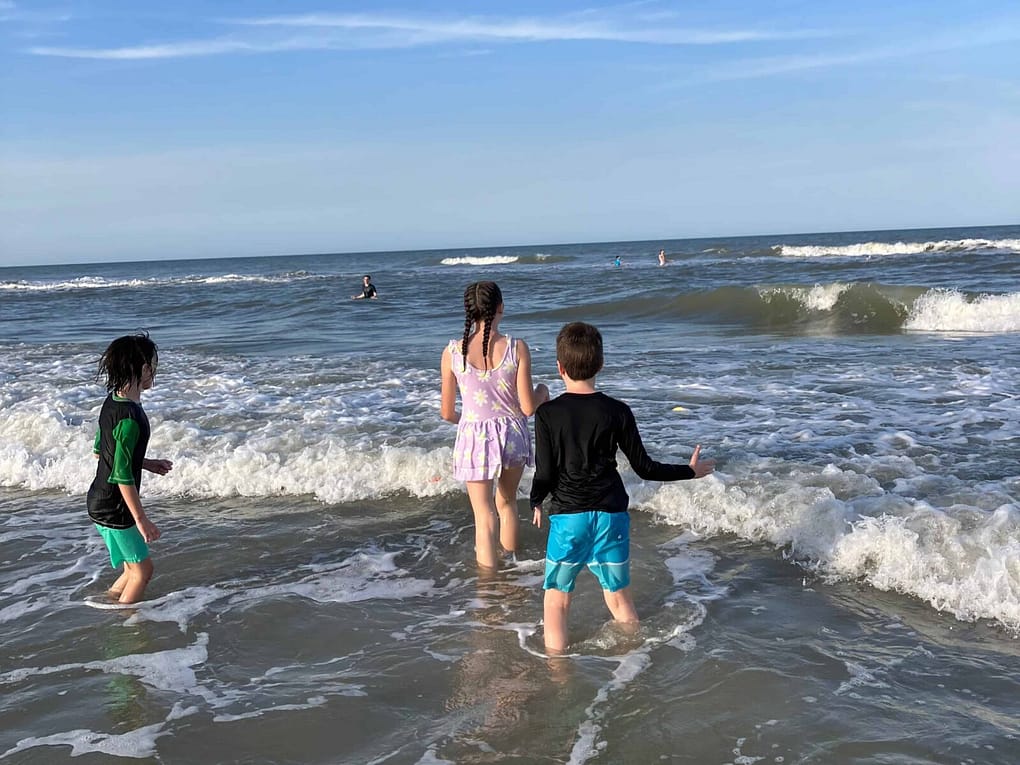 kids wading into the ocean