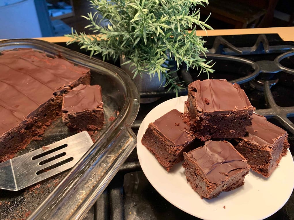 pan of brownies with plate of brownies next to it
