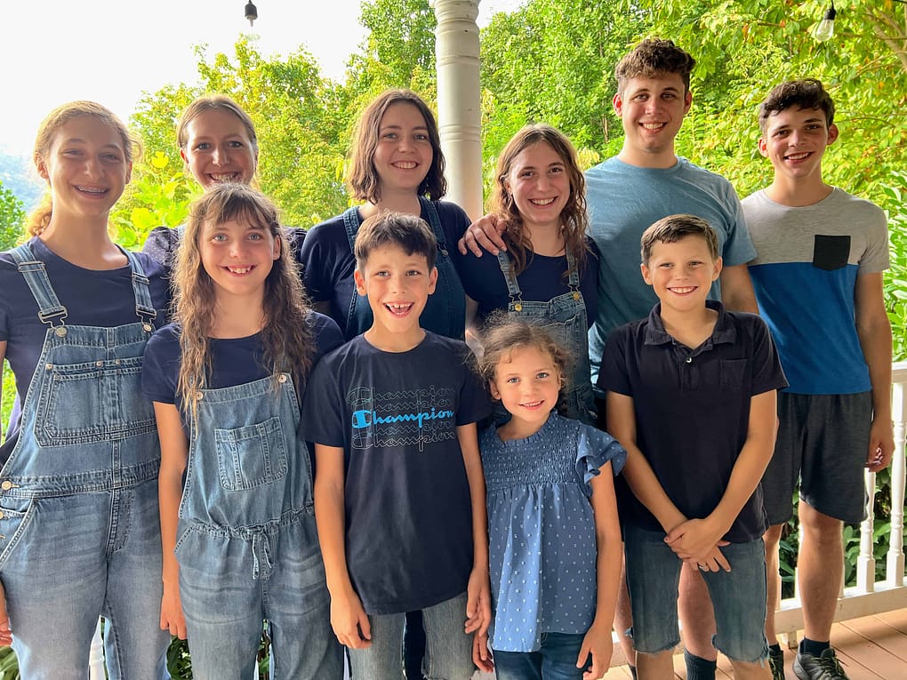 10 siblings wearing navy pose for the camera