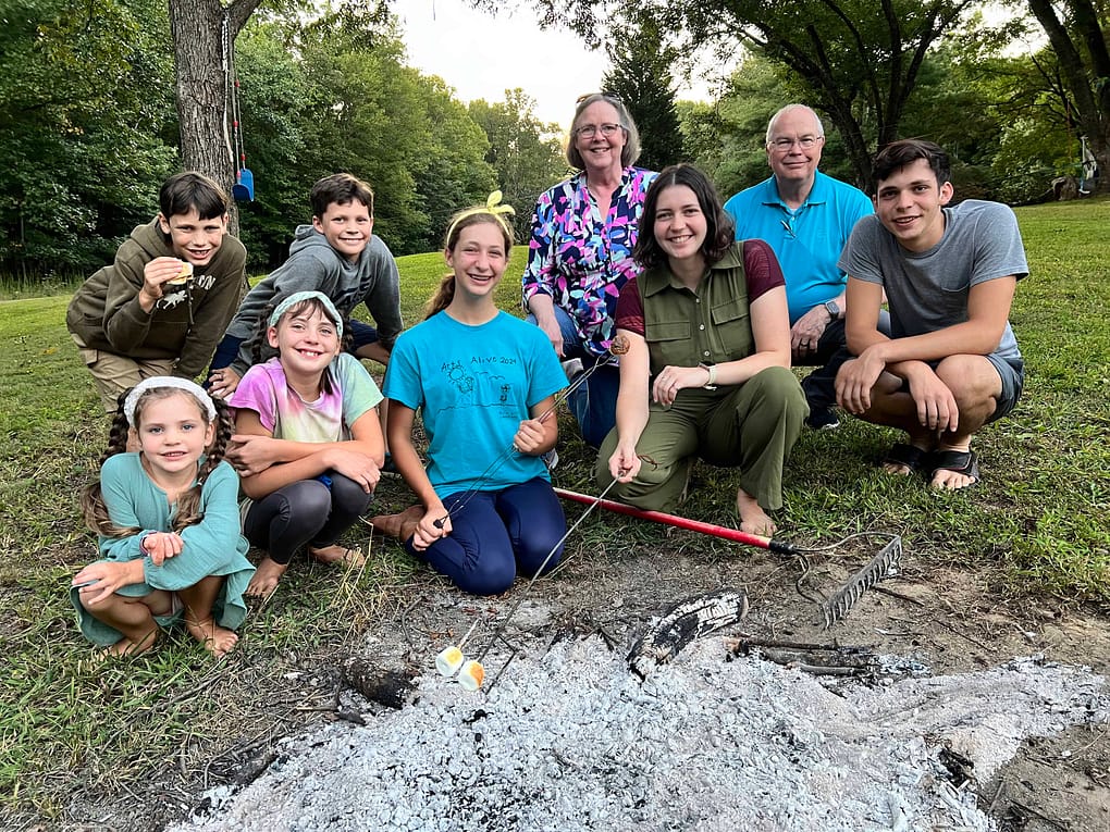 family around the coals of a campfire
