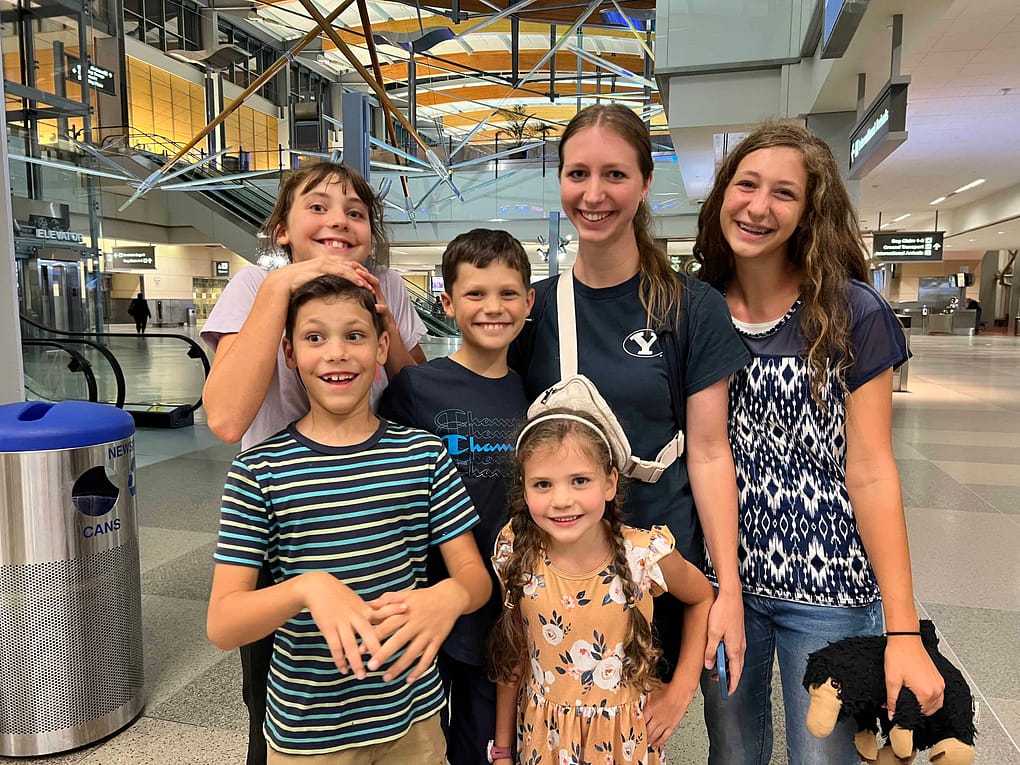 5 siblings greeting a sister who just got off the plane