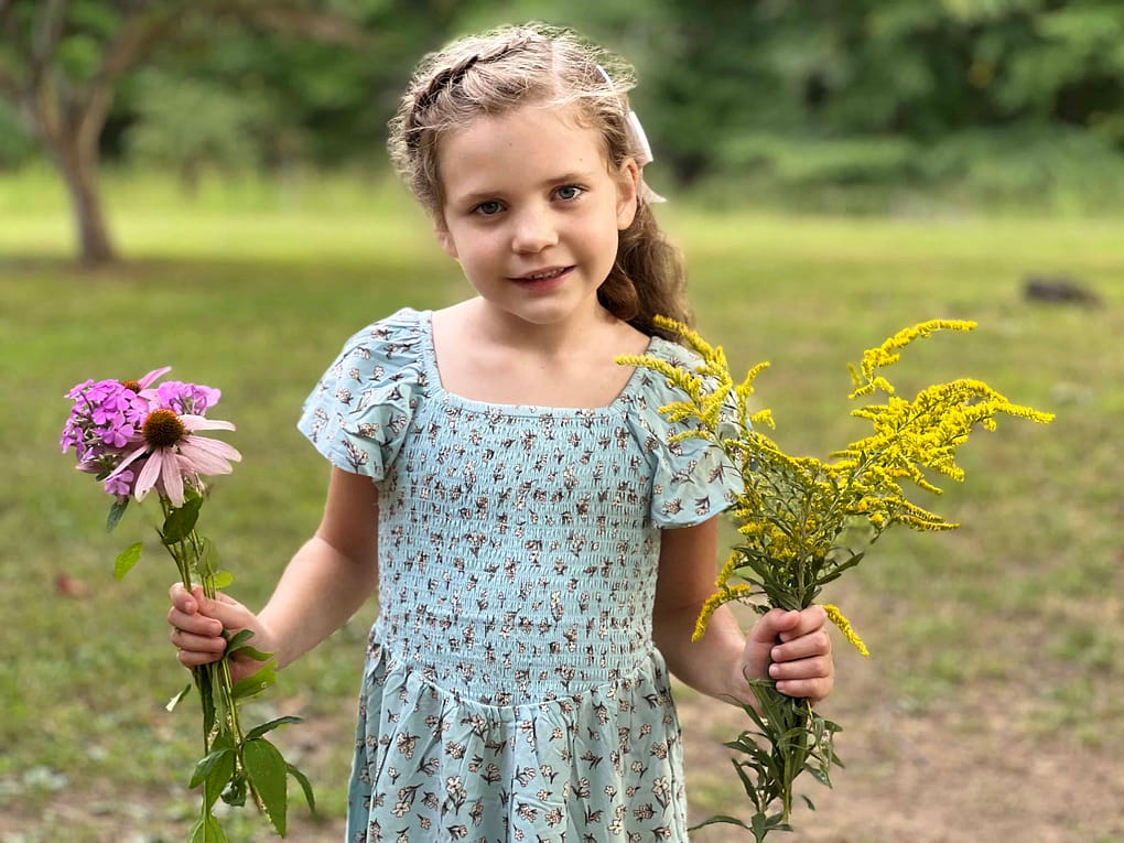 7 year old girl holding wildflowers