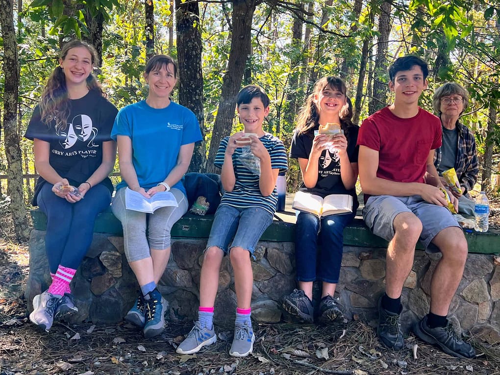 family eating sandwiches outside