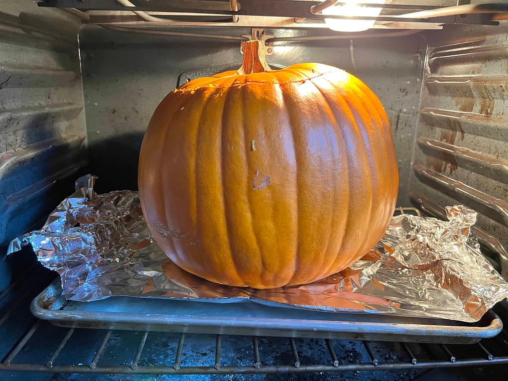 Pumpkin with dinner inside it put in the oven.