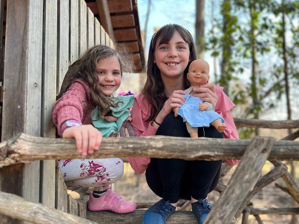 two sisters on perch on big birdhouse