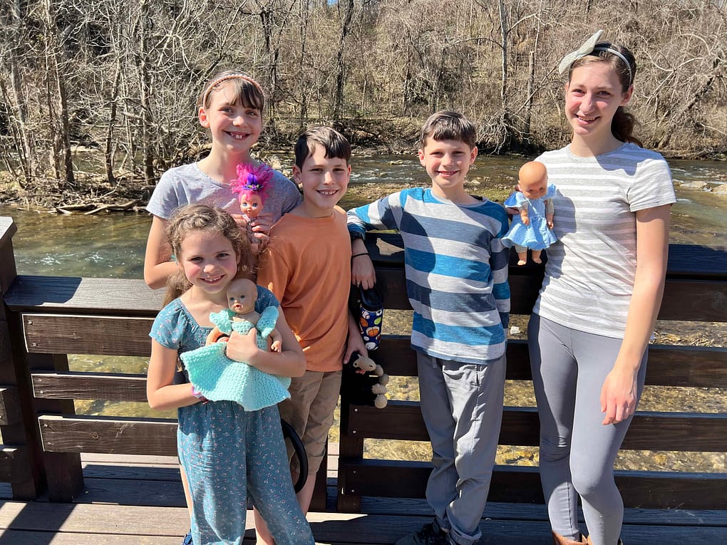 five siblings on a dock by the river