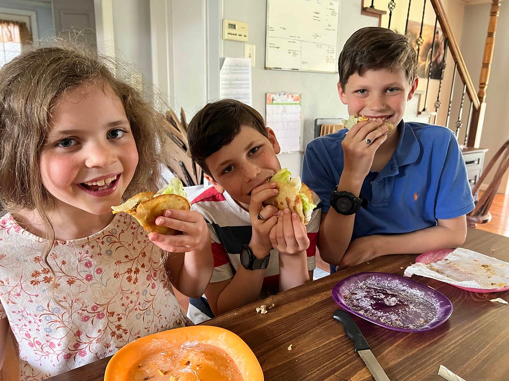 3 kids eating tacos
