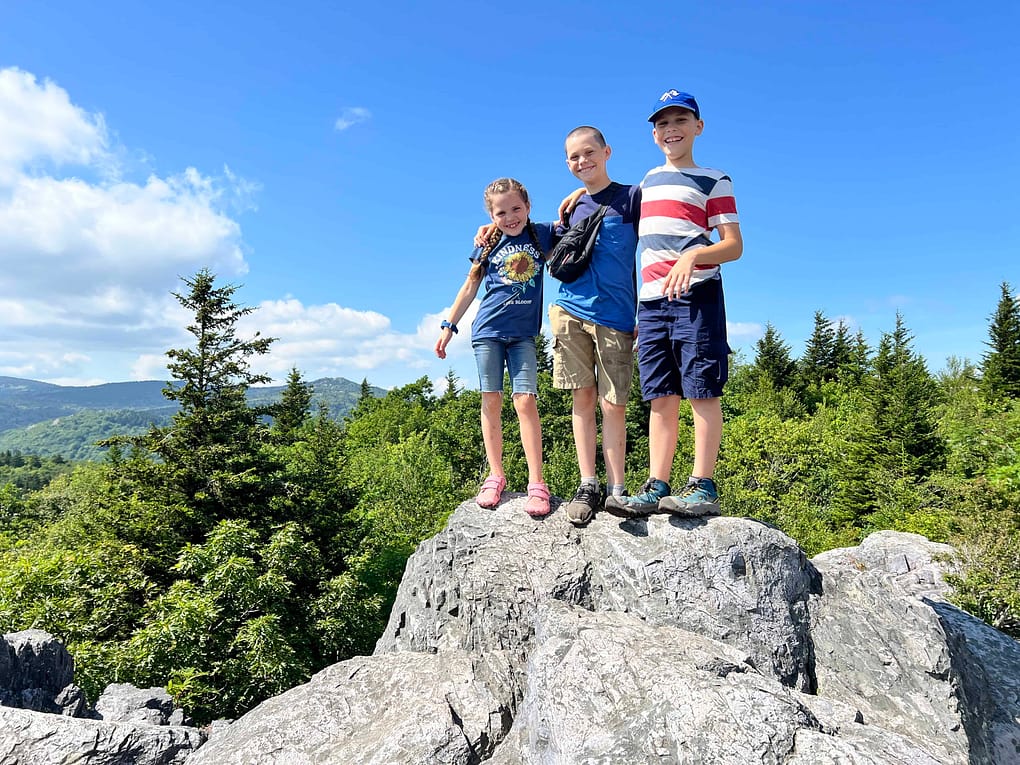 3 siblings on top of a rock at Grayson Highlands hike