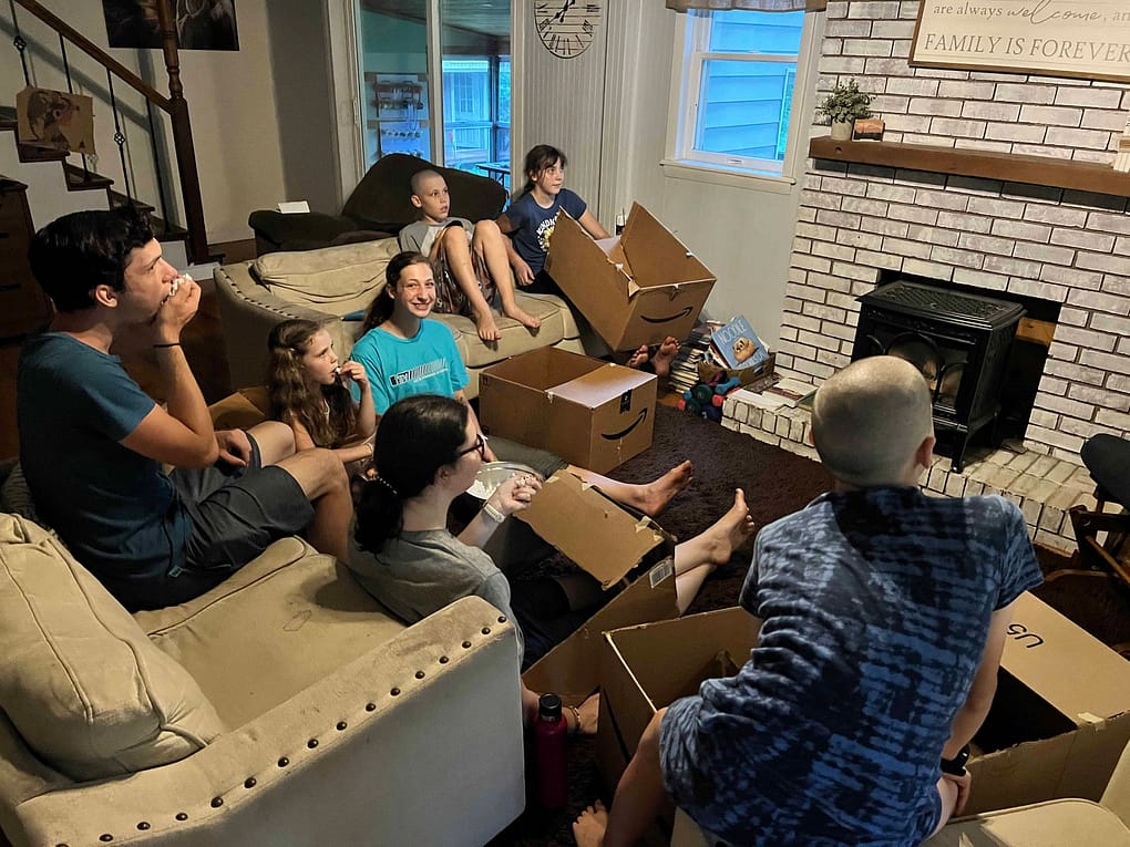 family watching a movie sitting in cardboard cars