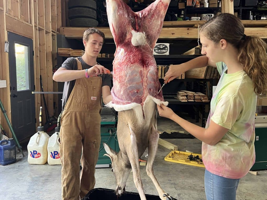 2 teens skinning a deer