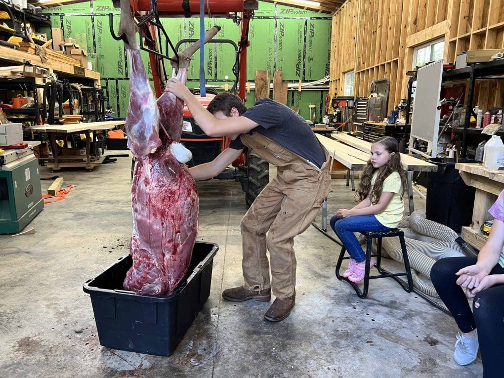 teen boy skinning a deer