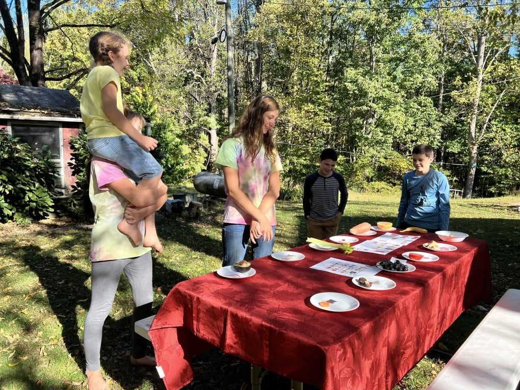 kids standing around a table outside setup for an activity