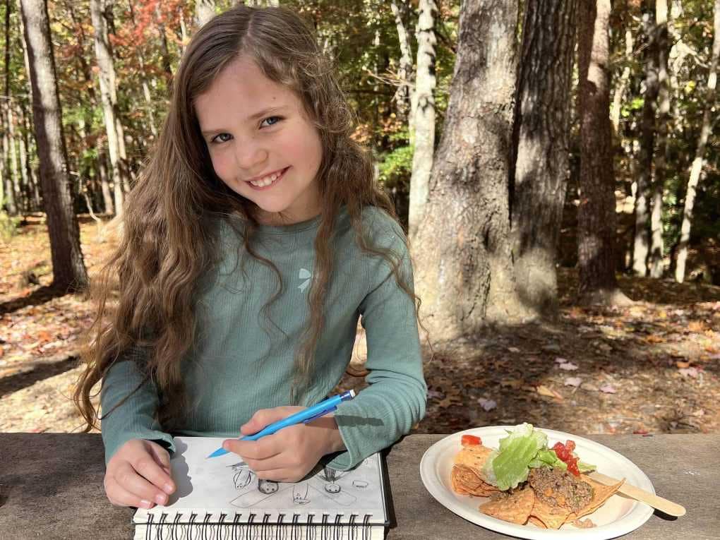 girl sketching while camping