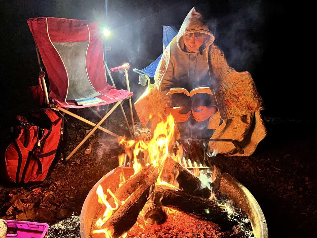girl sitting by campfire