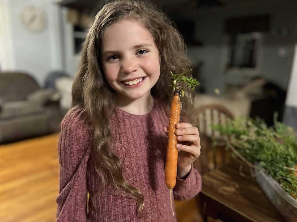 girl with homegrown carrot