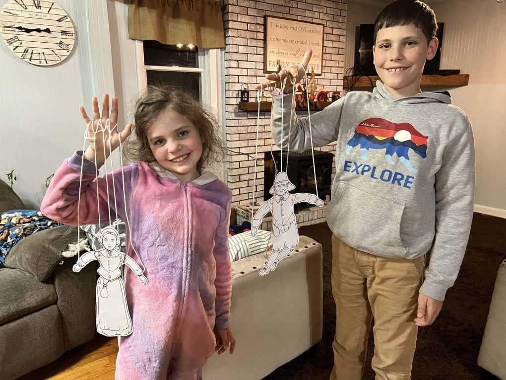 two kids playing with paper puppets
