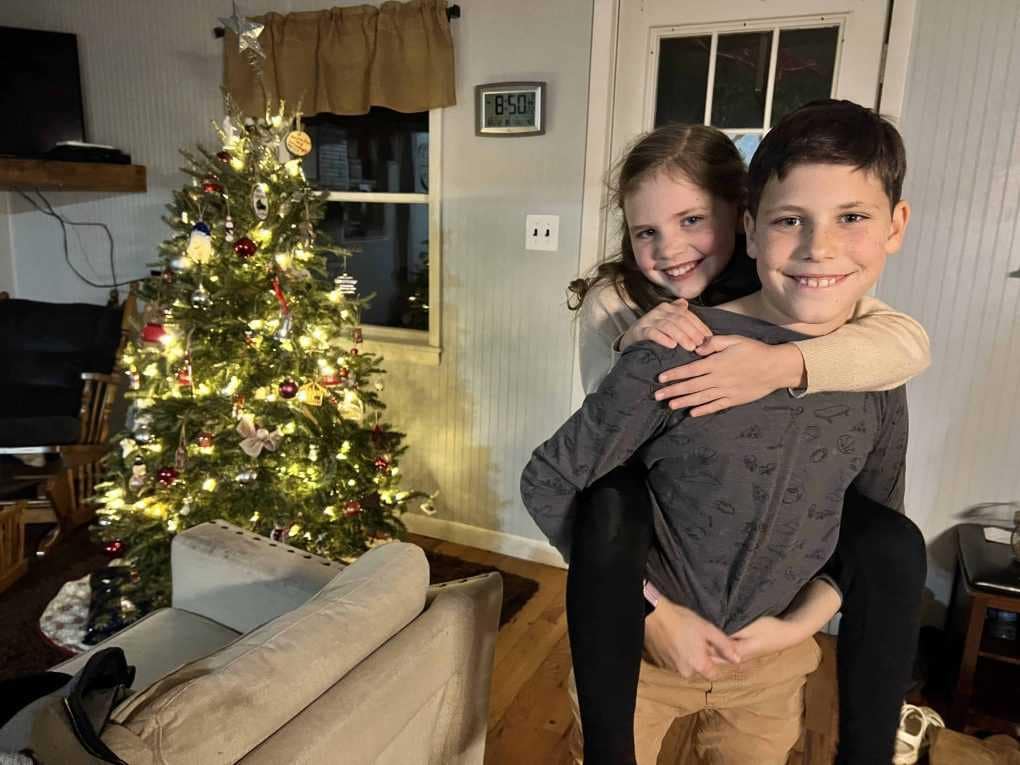 two kids by a Christmas tree