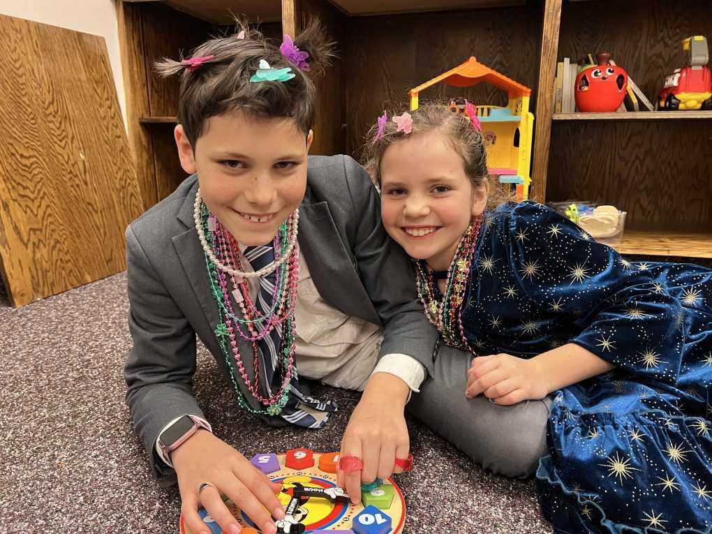 brother and sister putting plastic jewelry on