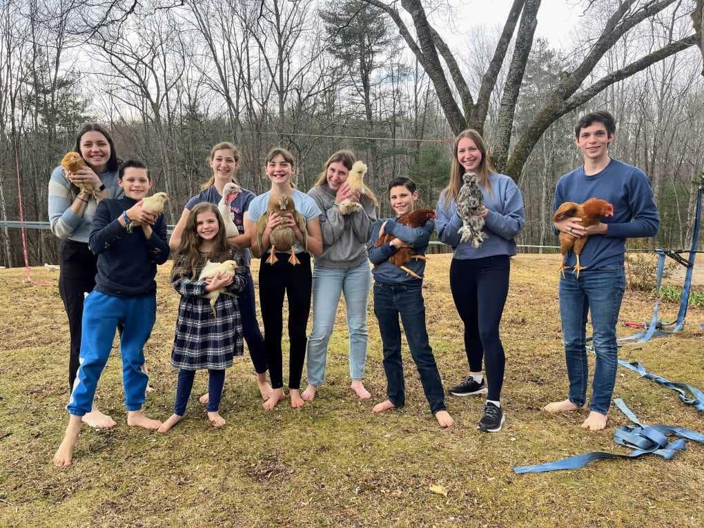 9 kids holding chickens