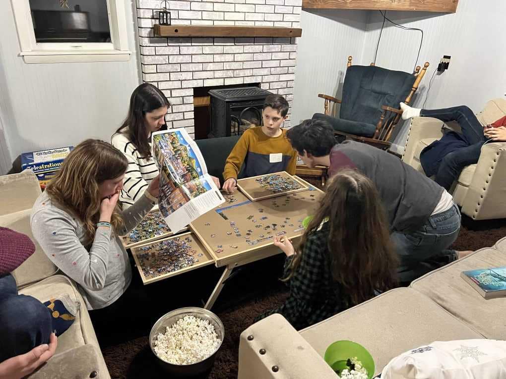 siblings eating popcorn and doing a puzzle