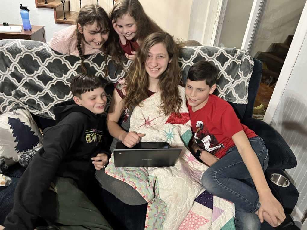 5 kids looking at a computer