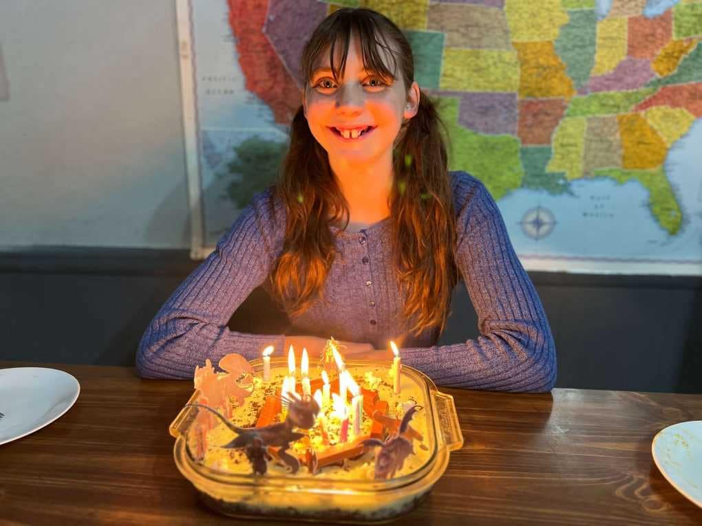 14 year old girl with birthday treat and candles