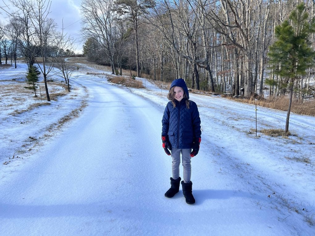 girl standing on road completely iced over