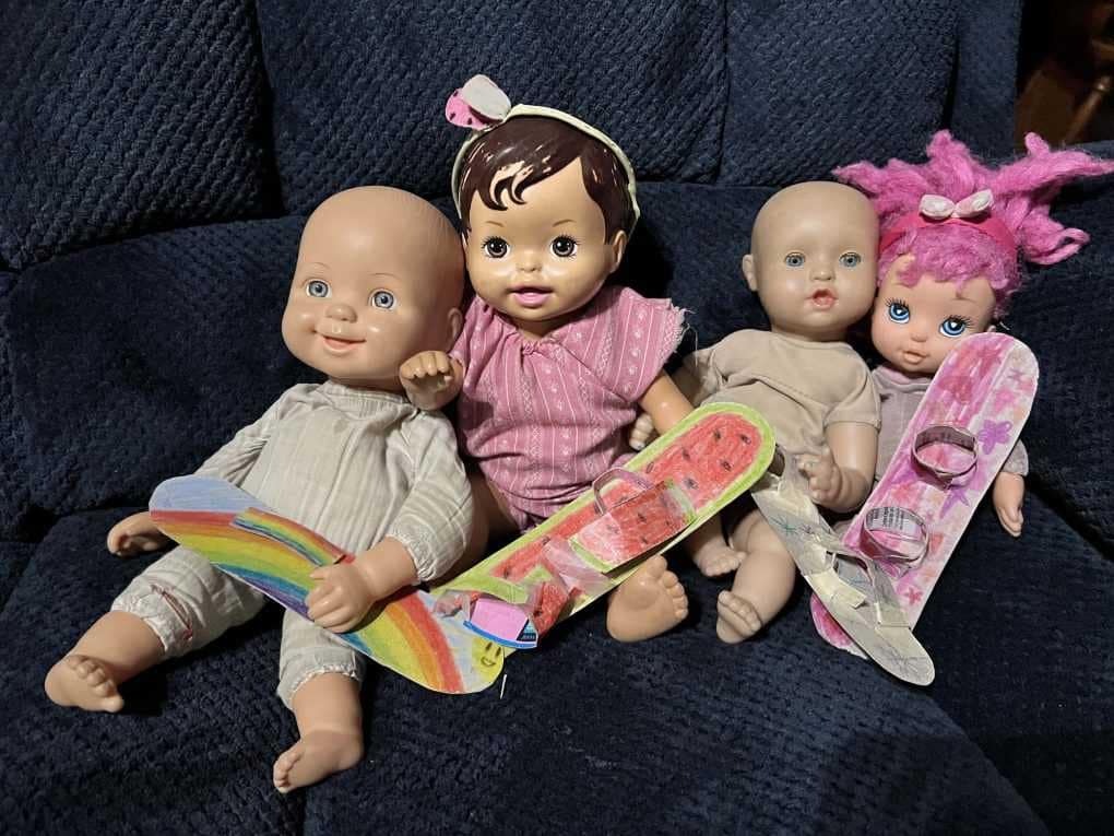 4 dolls with cardboard snowboards