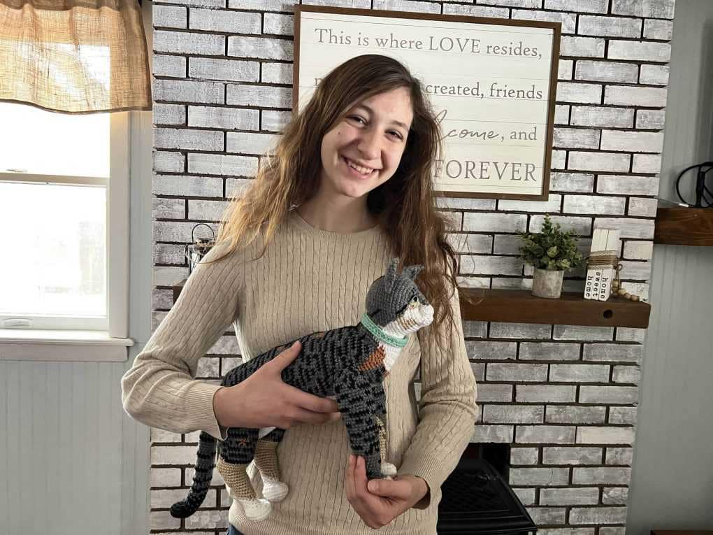 teen girl holding crocheted cat