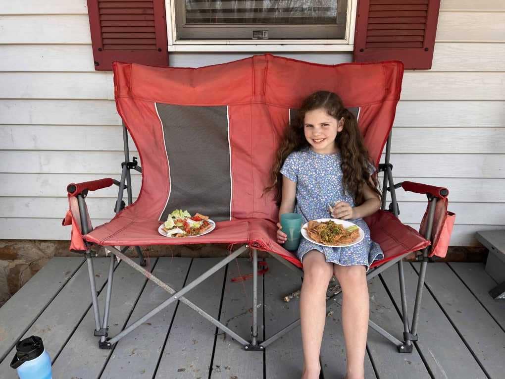 girl eating lunch on porch
