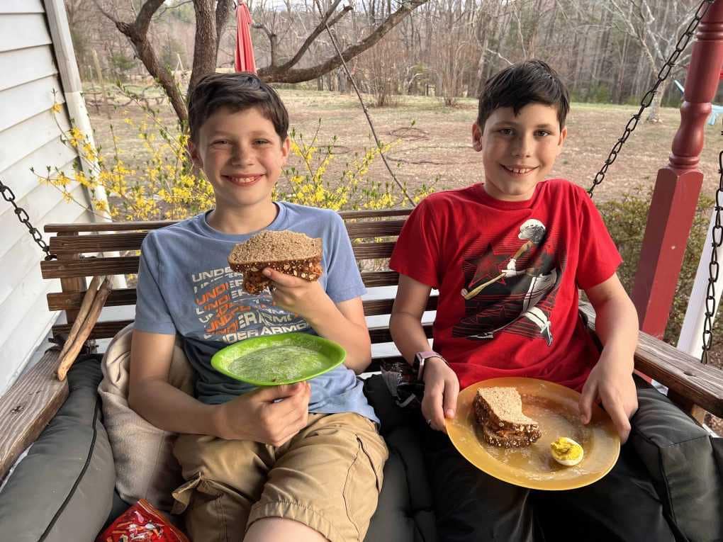boys eating lunch on porch swing