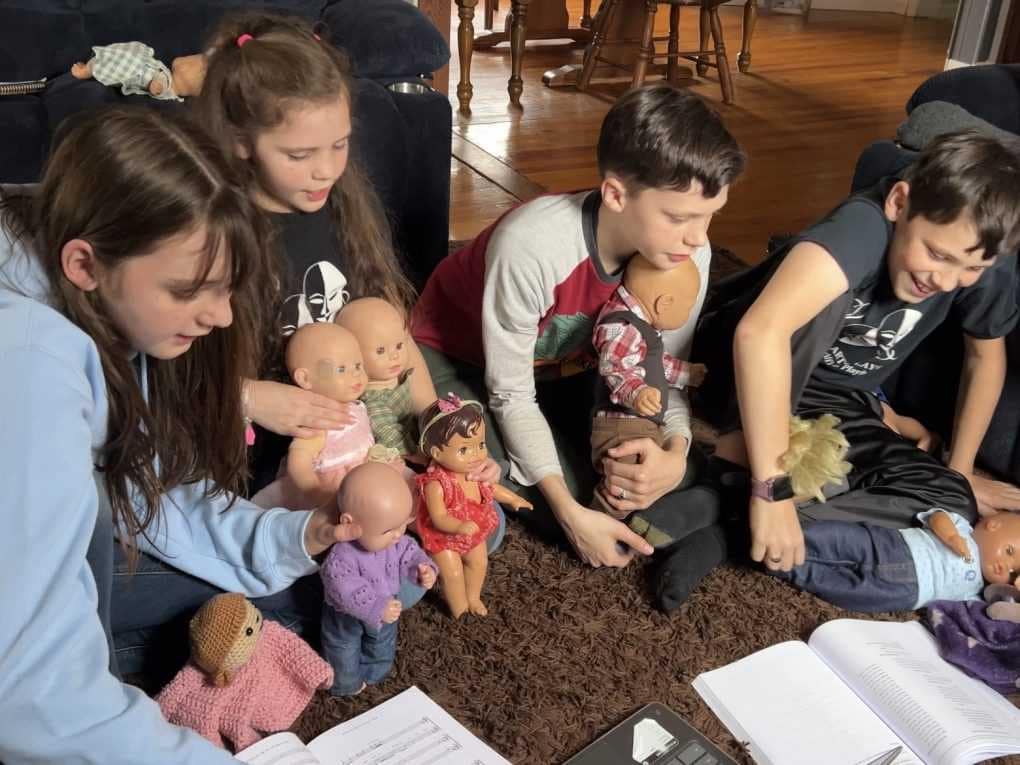 kids singing with dolls from a script