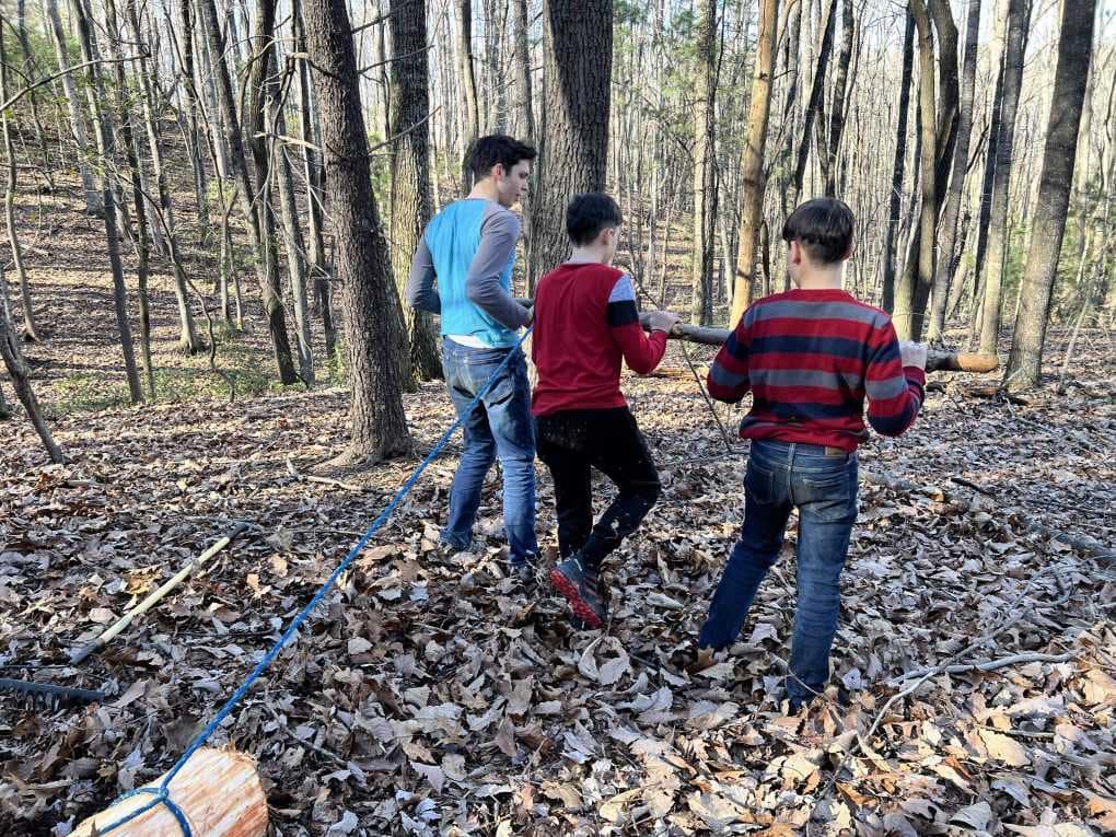 3 brothers dragging a large log