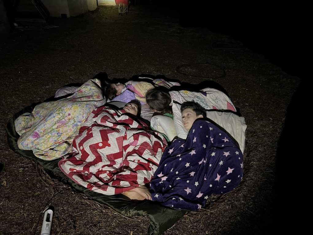 5 kids sleeping in a pile outside