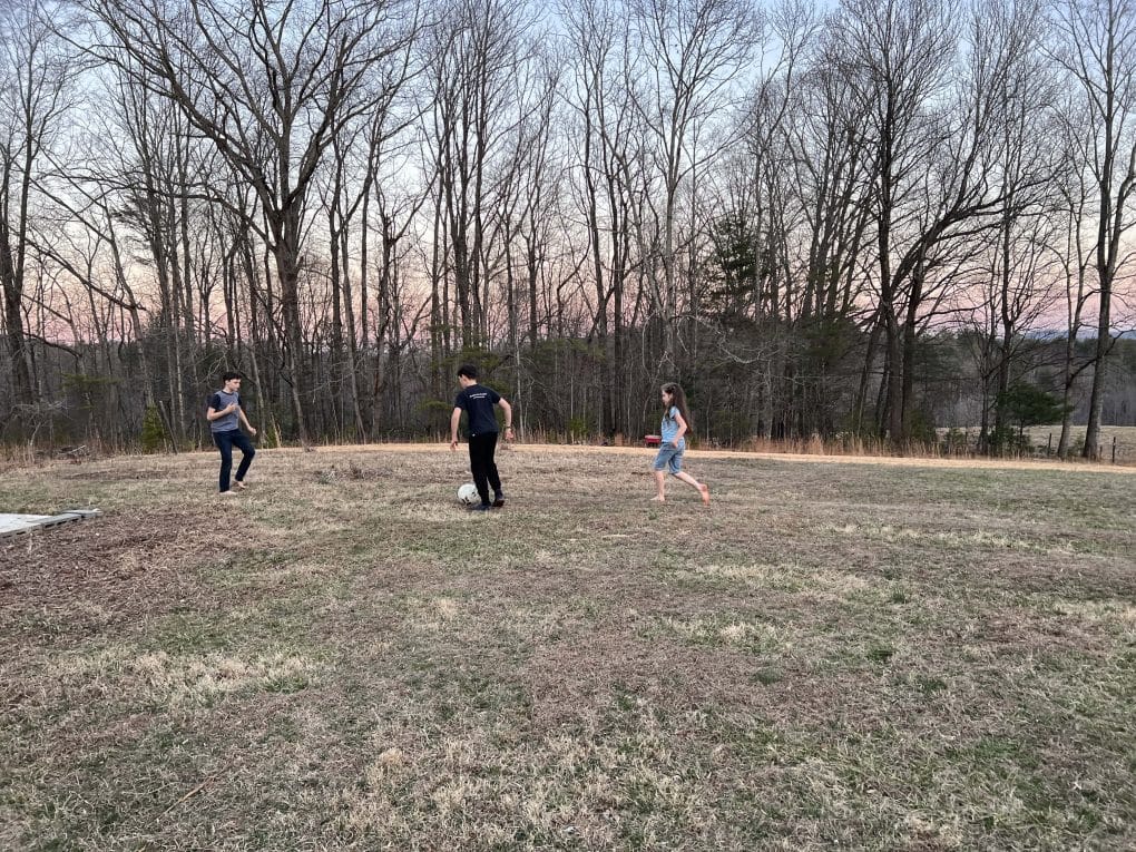 3 kids playing in a field in winter
