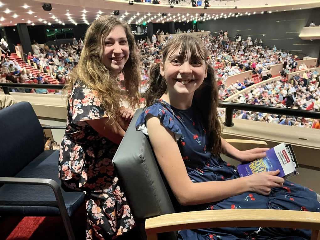 2 sisters watching a play in box seats